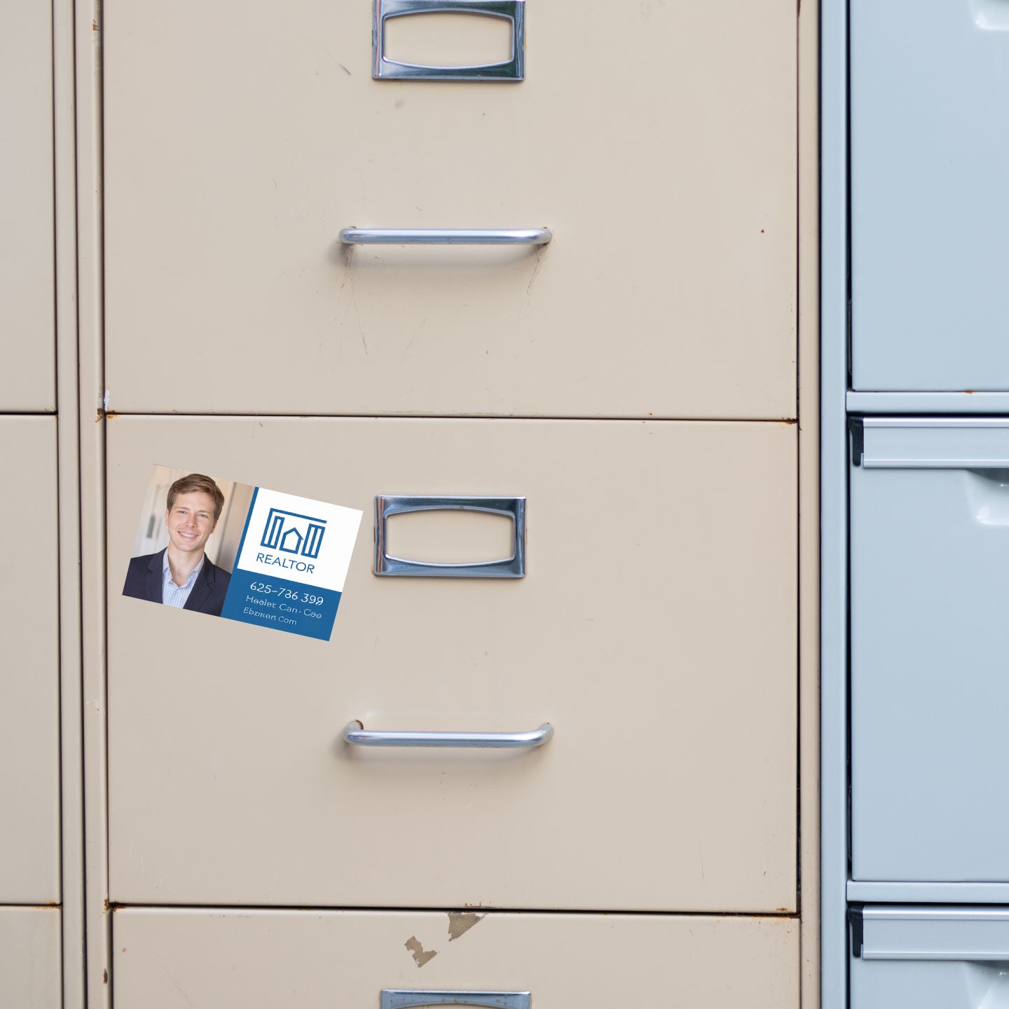 Filing cabinet with a business card magnet attached to one of the drawers