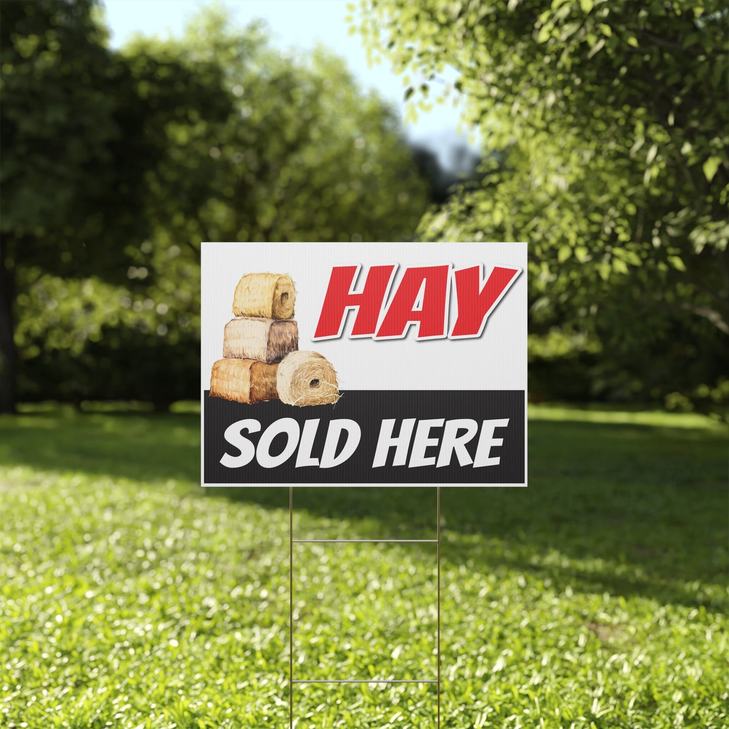 Hay sold here sign on a grassy lawn with trees in the background