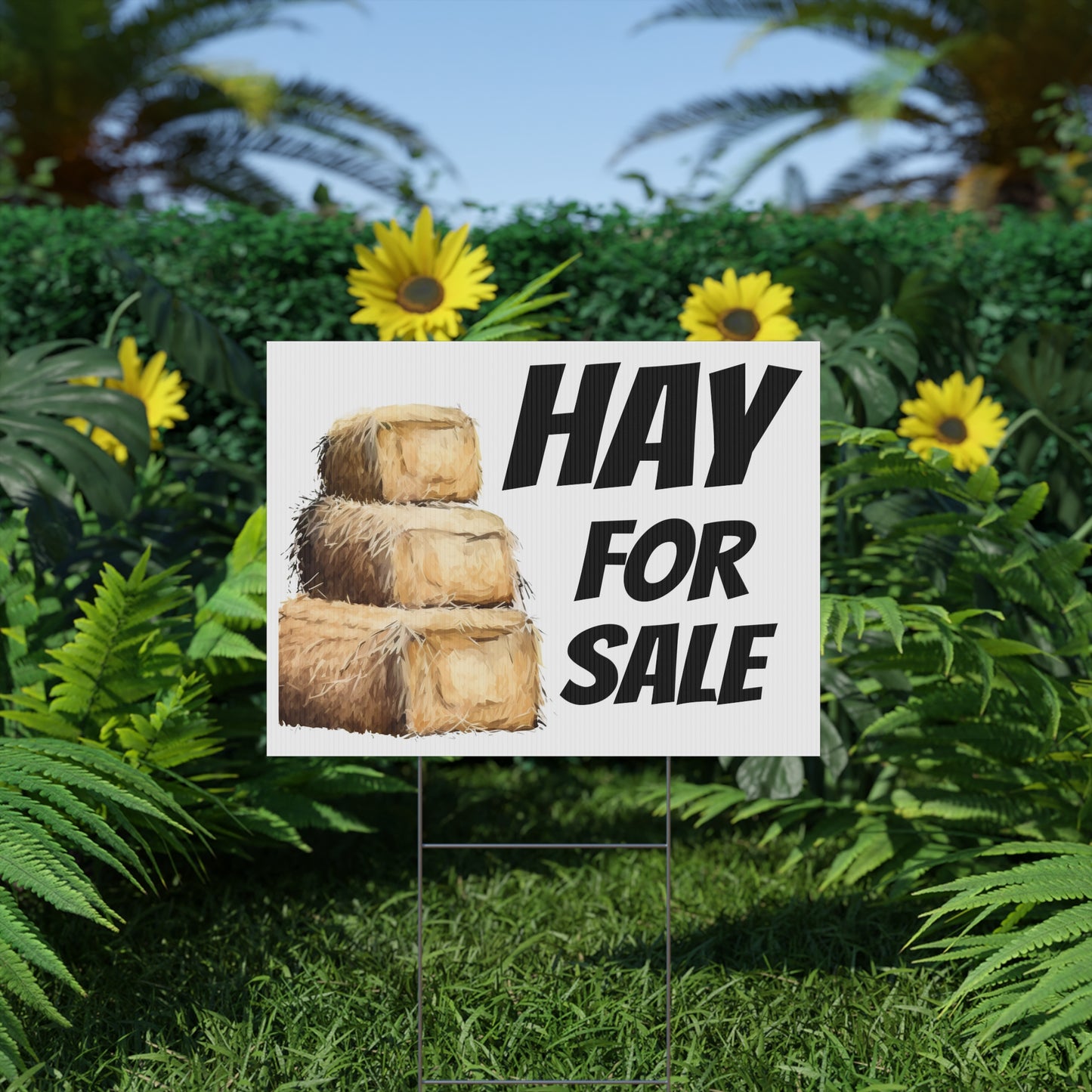 Hay for sale sign in a garden setting with greenery and flowers.