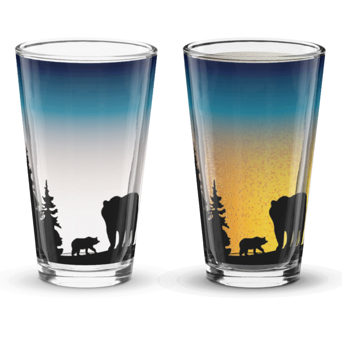 Two glass tumblers with bear and forest design on a sunset background