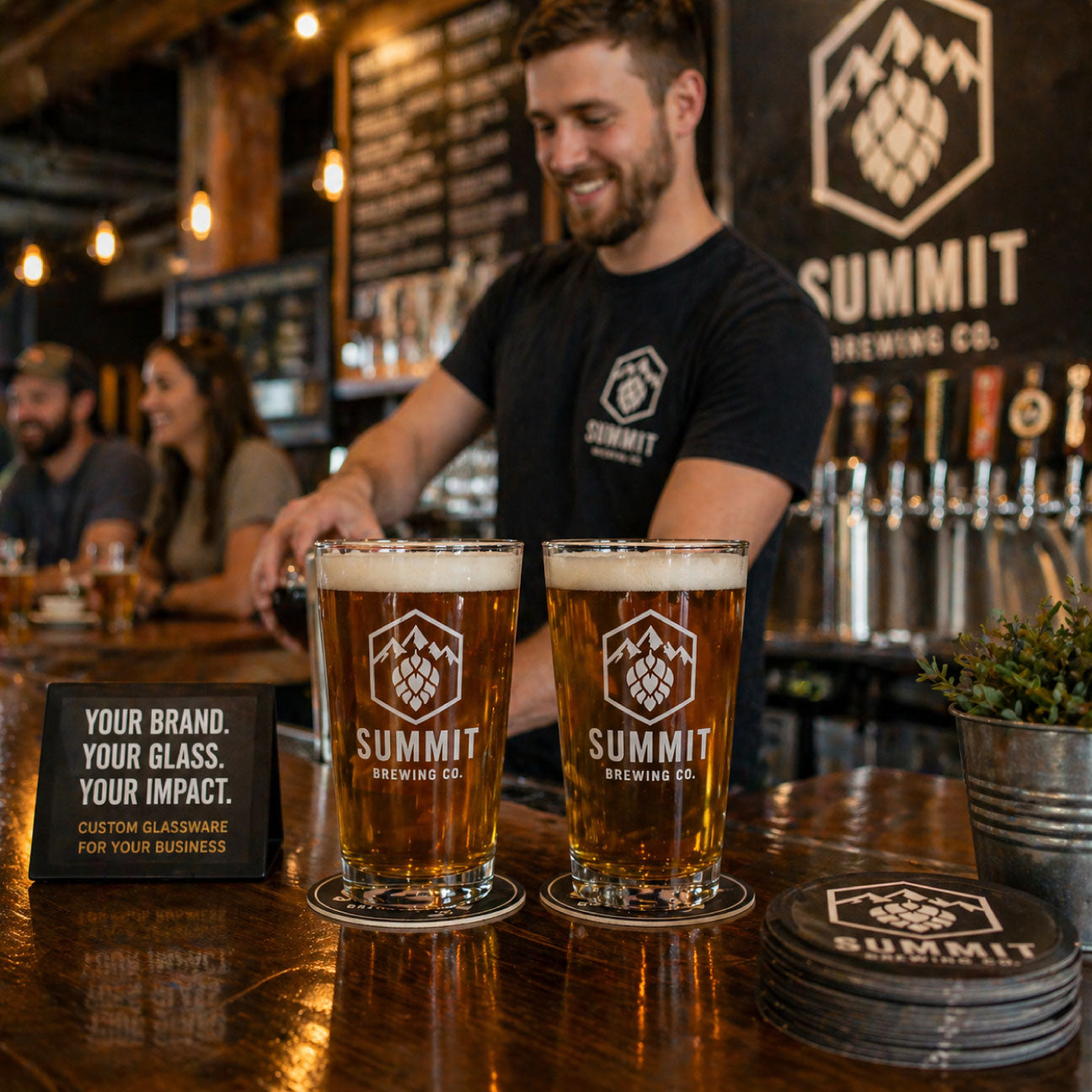 Person serving Summit Brewing Co. beer at a bar with branded glasses.