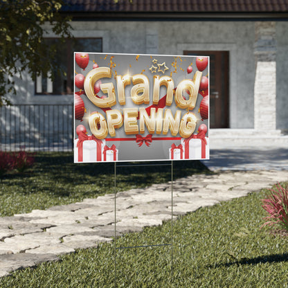 Grand opening square yard sign with balloons and presents on a grassy lawn in front of a house.