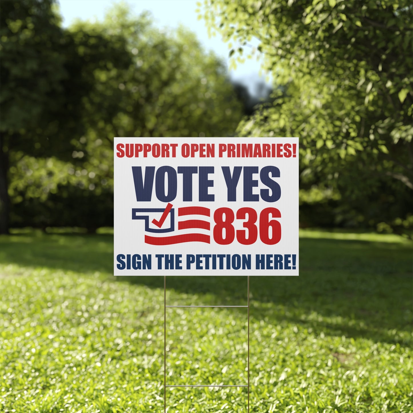 Political campaign sign on grass with trees in the background