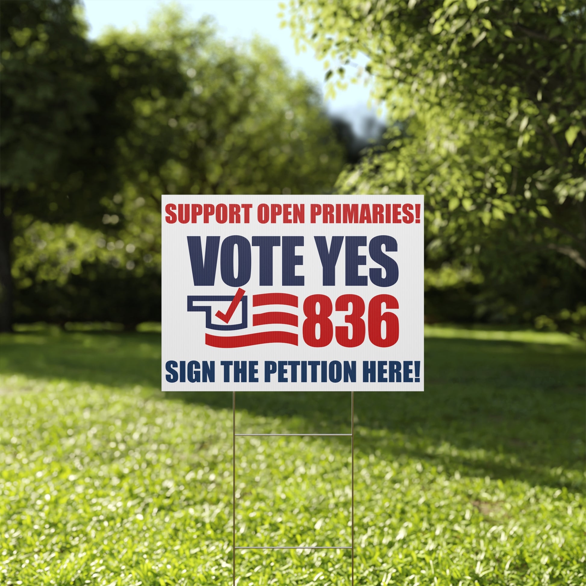 Political campaign sign on grass with trees in the background